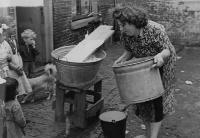 876860 Afbeelding van Marie van de Ham die de was doet, voor haar woning vermoedelijk op de Kroonhof in Wijk C te ...